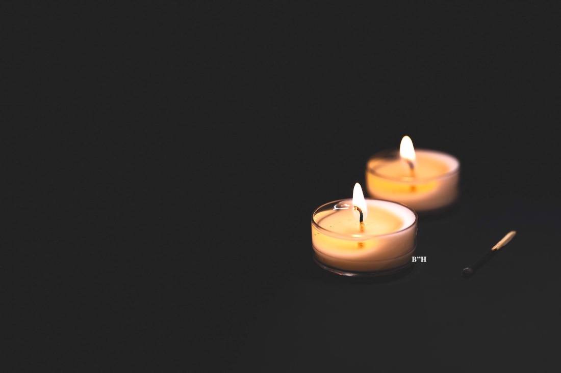 2 memorial yahrzeit candles on black background