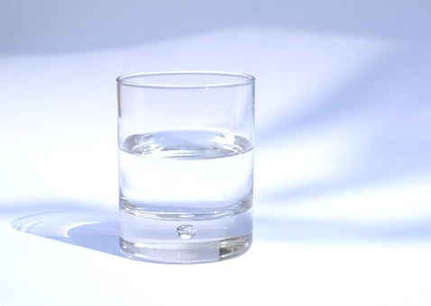 half empty or half full glass on blue and white background